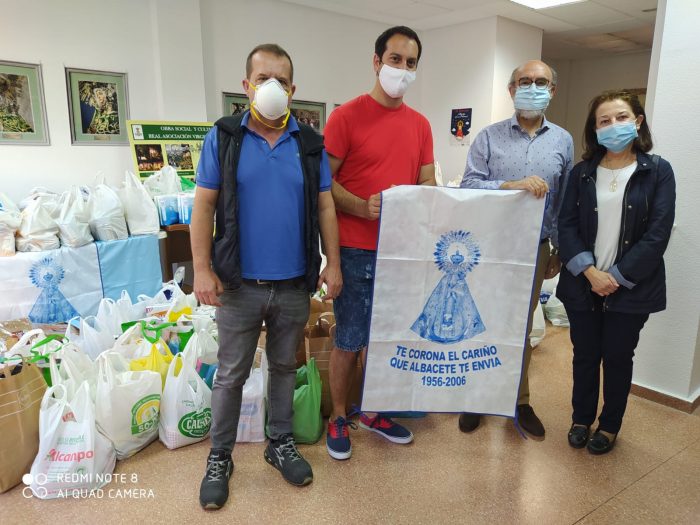 Miembros de la Asociación Virgen de los Llanos hacen entrega de los productos de primera necesidad recogidos.